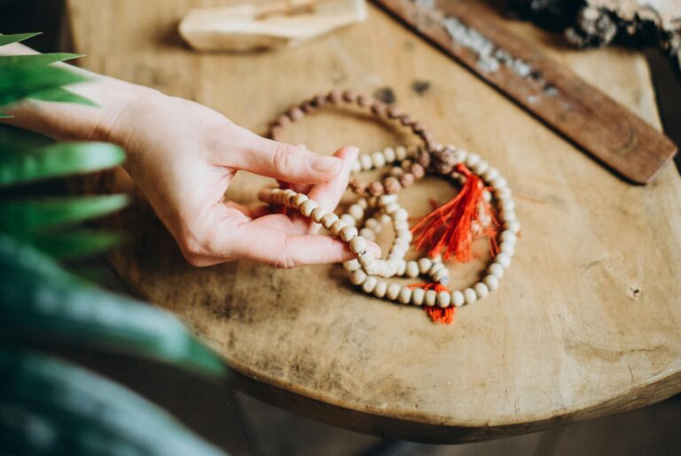 Model gently twirling Feng Shui bracelet beads with fingers