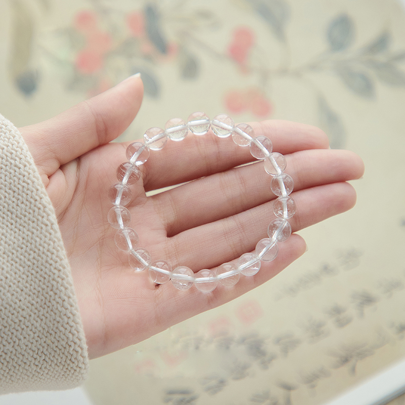 Model holding the Clear Insight Crystal Charm Bracelet in hand