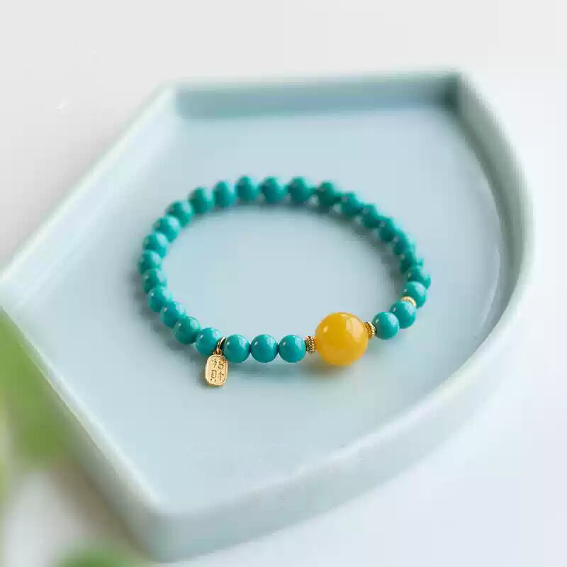 Turquoise bracelet placed in a celadon ceramic dish