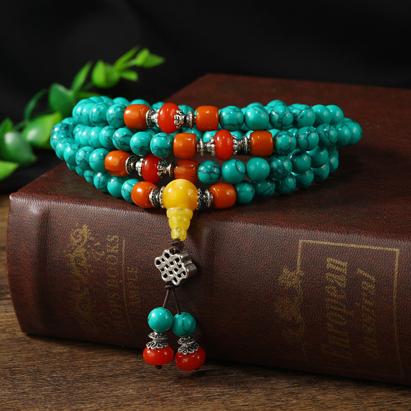Green turquoise mala bracelet placed on ancient book
