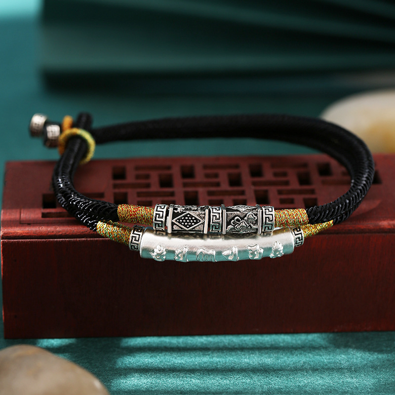 Black Buddhist bracelet on a jewelry box showing dual-layer design
