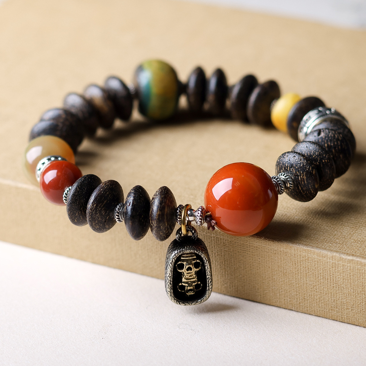 Tibetan Vajra Red Agate & Agarwood Bracelet on a jewelry tray