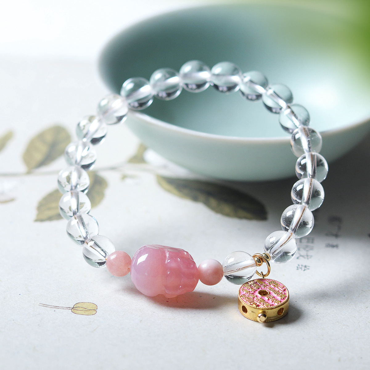 Bracelet draped on the edge of a green porcelain bowl