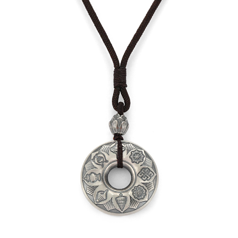 Front view of Tibetan silver pendant with Eight Auspicious Symbols on white background