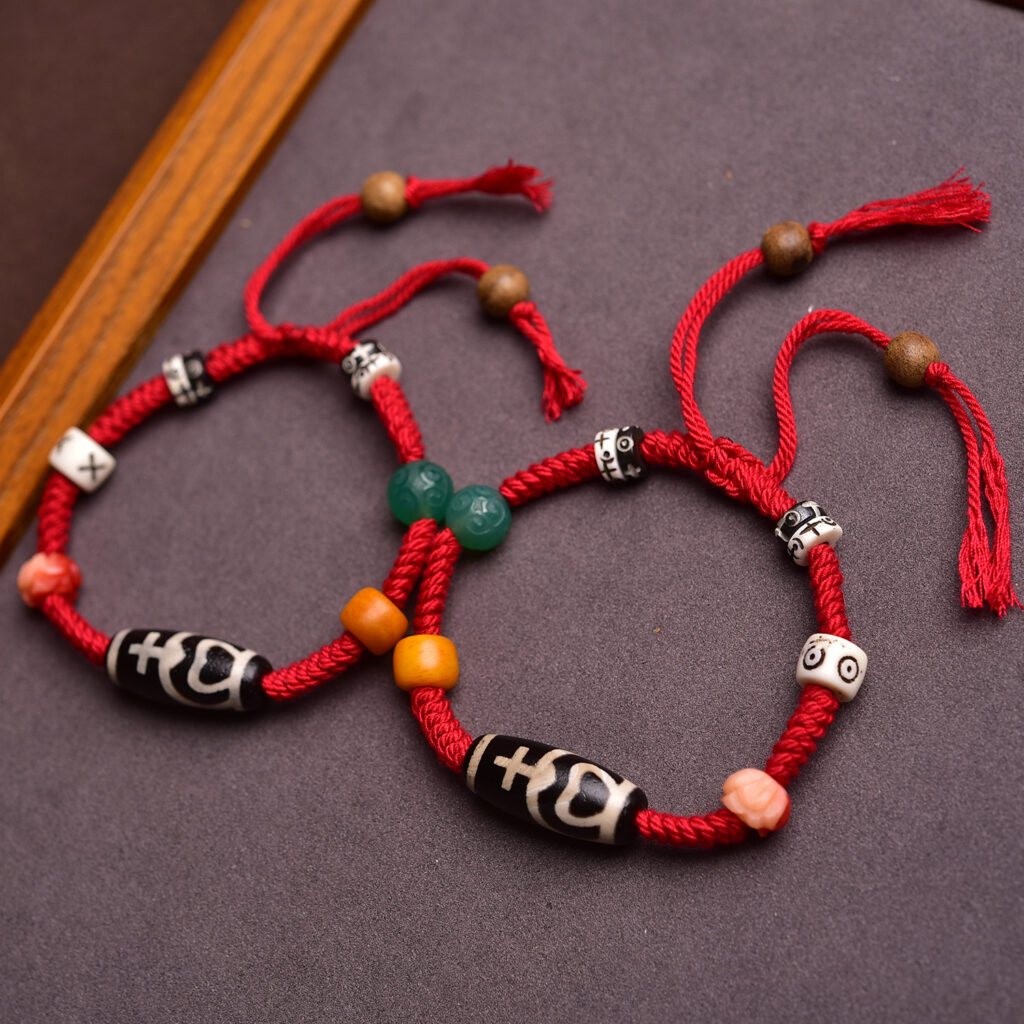 Two Tibetan red string bracelets displayed side by side