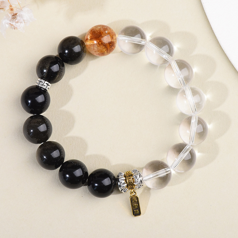 Clear quartz side glowing under soft pink fabric, yin yang bracelet