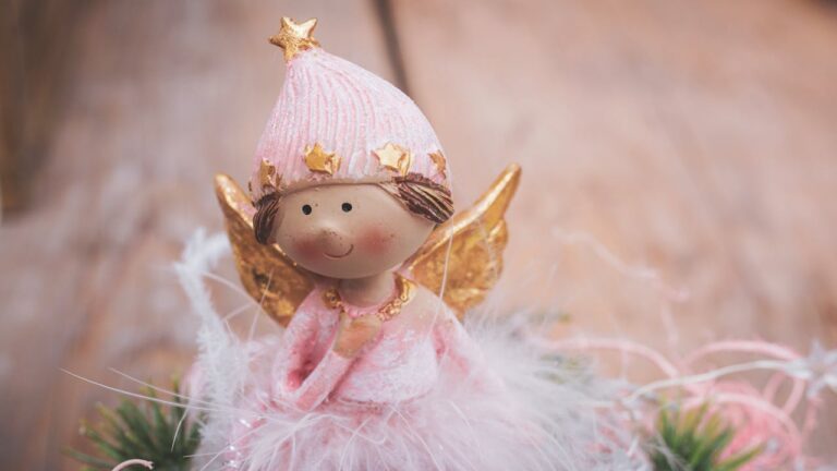 Ceramic angel doll on a soft pink background, symbolizing the gentle and spiritual energy of the 3030 angel number.