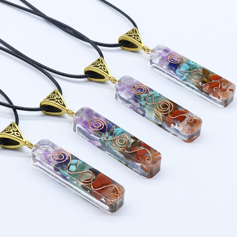 Four small 7 Chakra Orgone Pendants with chains on white background