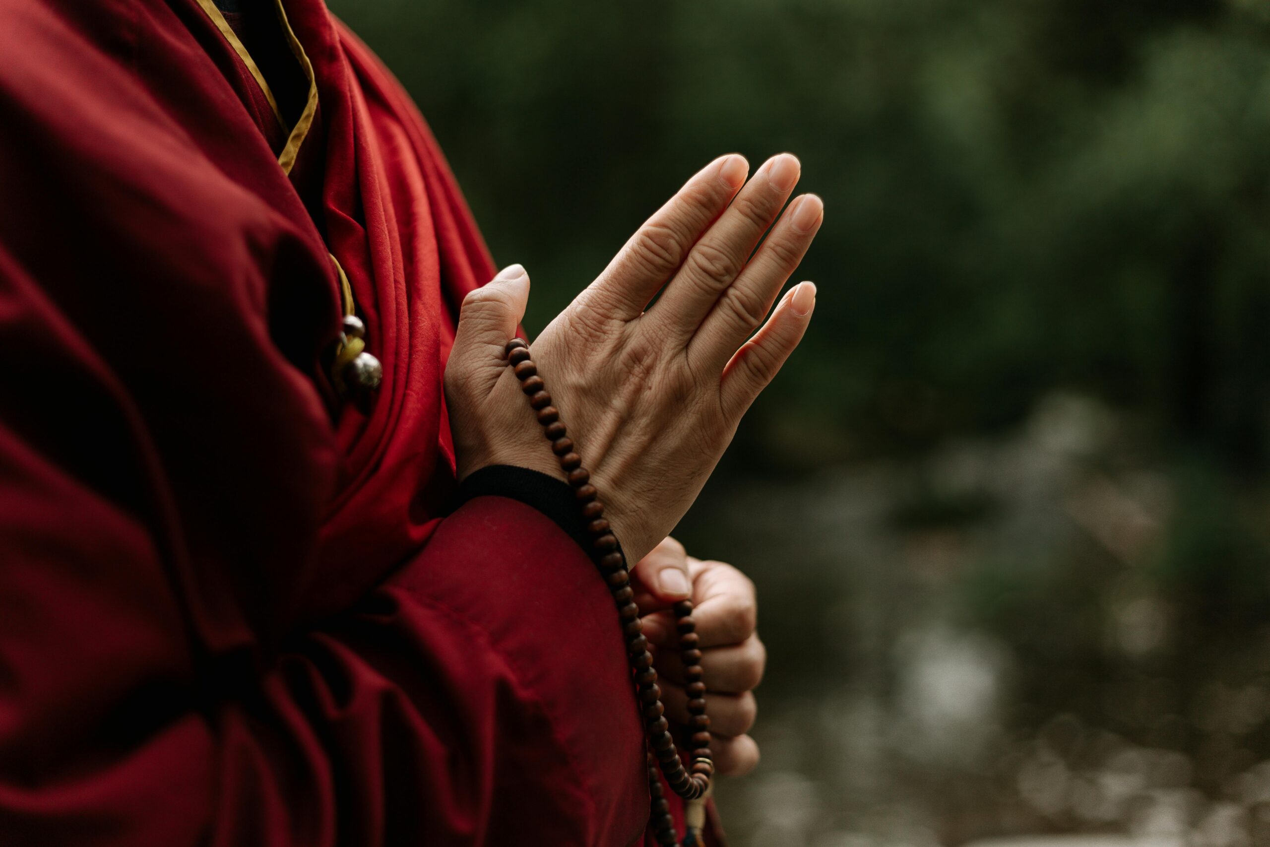 A Buddhist monk wearing a feng shui bracelet made of prayer beads, symbolizing spiritual protection and energy balance